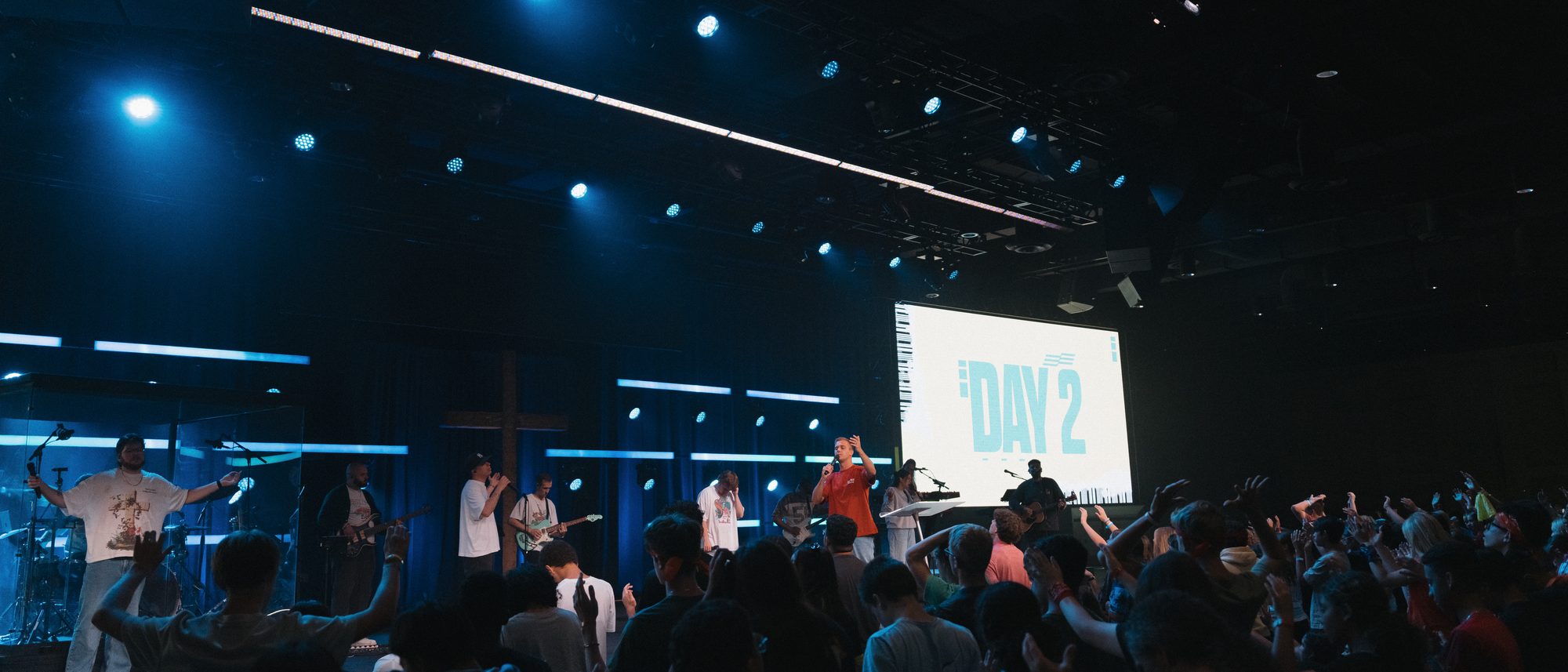 A worship service with hands raised across the room
